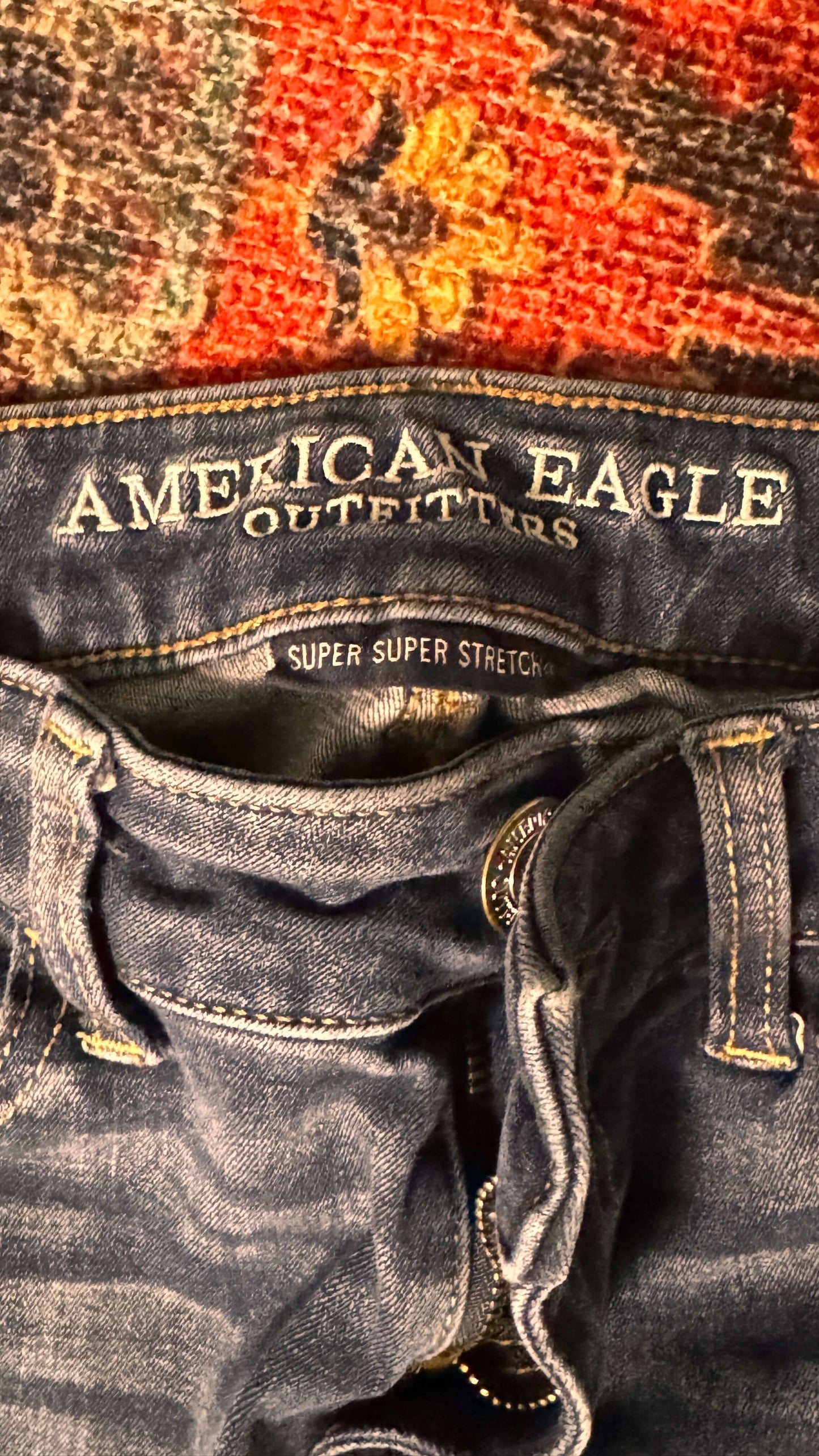 Close-up of American Eagle Outfitters denim waistband, showcasing super stretch material and brand label.