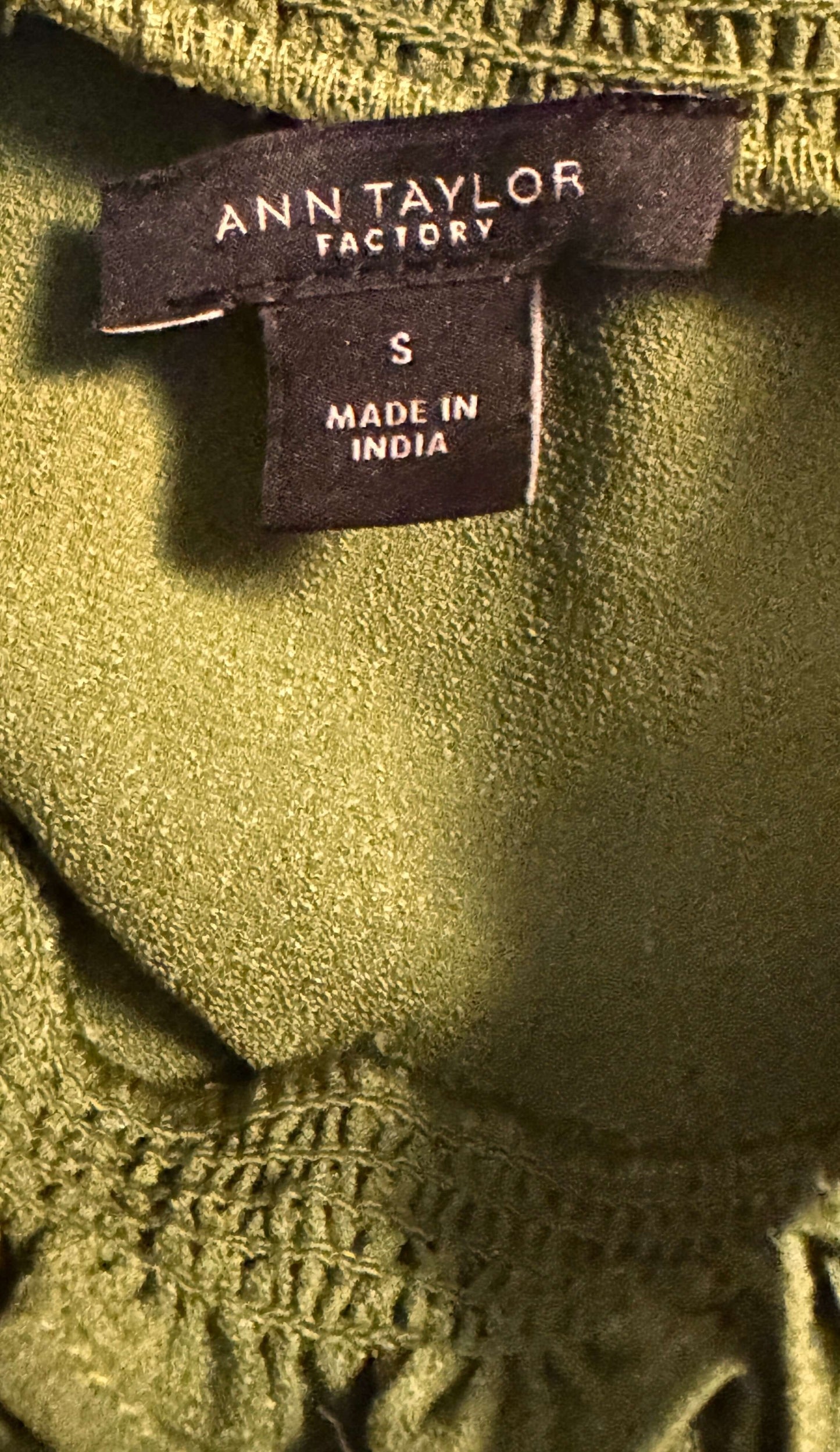 Ann Taylor sleeveless green blouse tag showing size small petite, made in India, perfect for stylish casual looks.