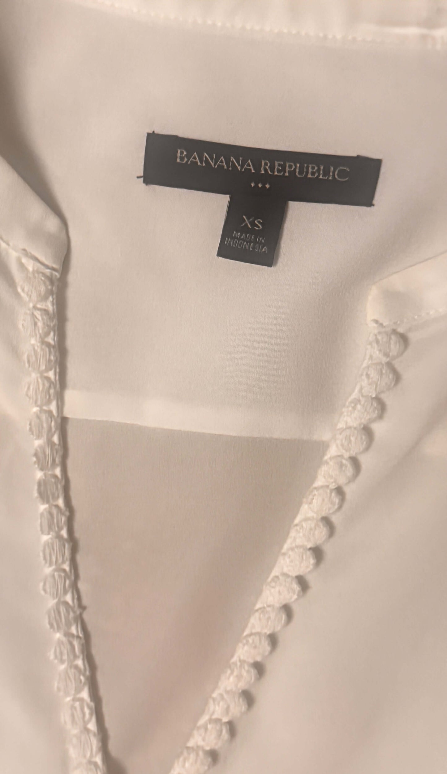 Close-up of a Banana Republic label on a garment with decorative trim.
