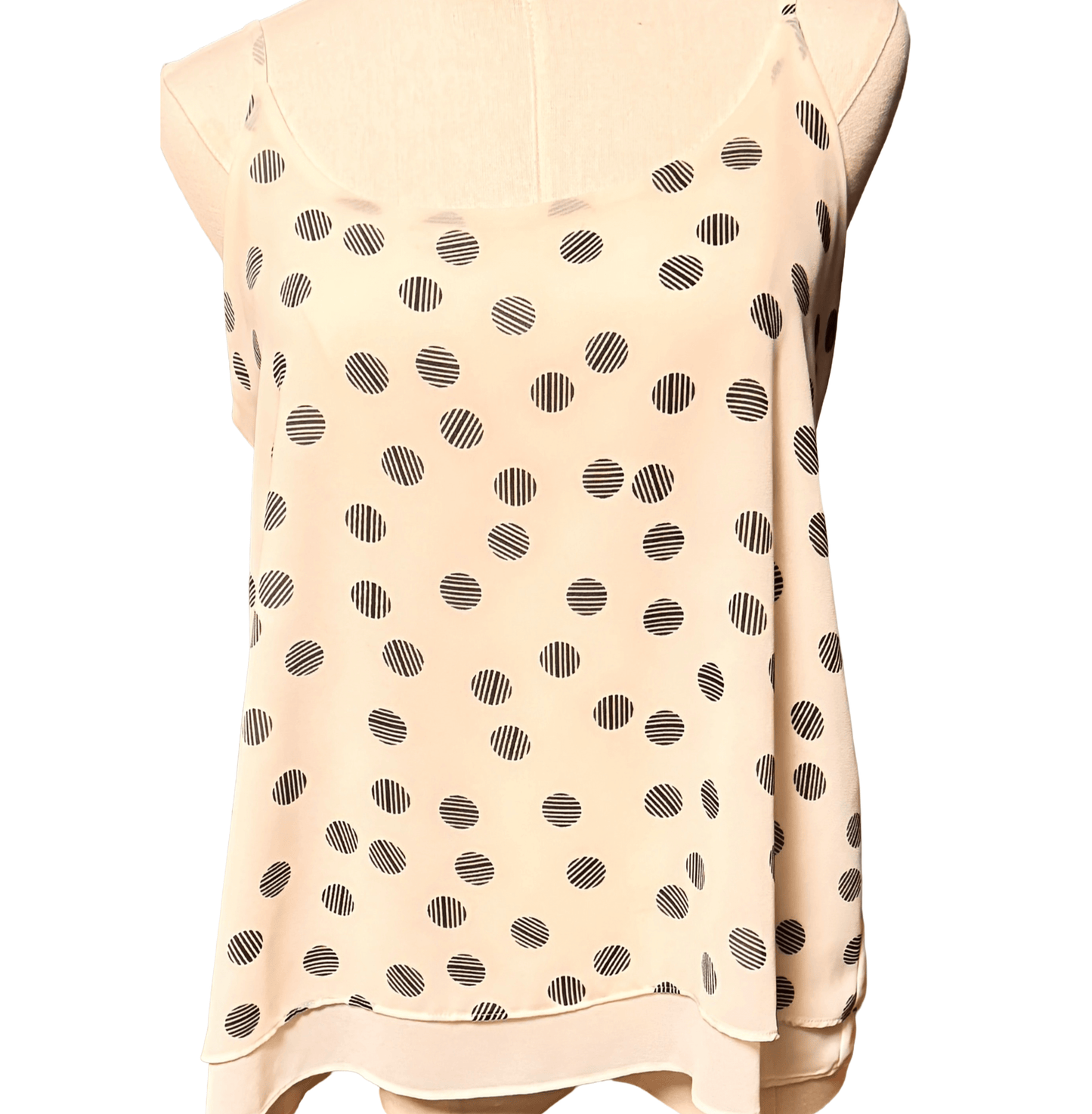 Beige sleeveless top with black polka dot pattern on a white background