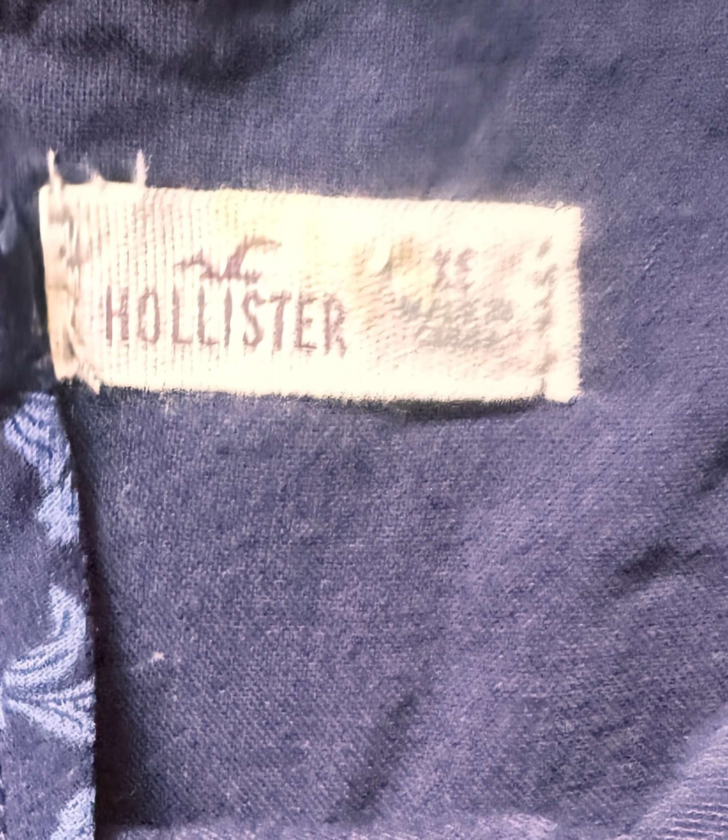 Hollister label on a dark blue fabric background