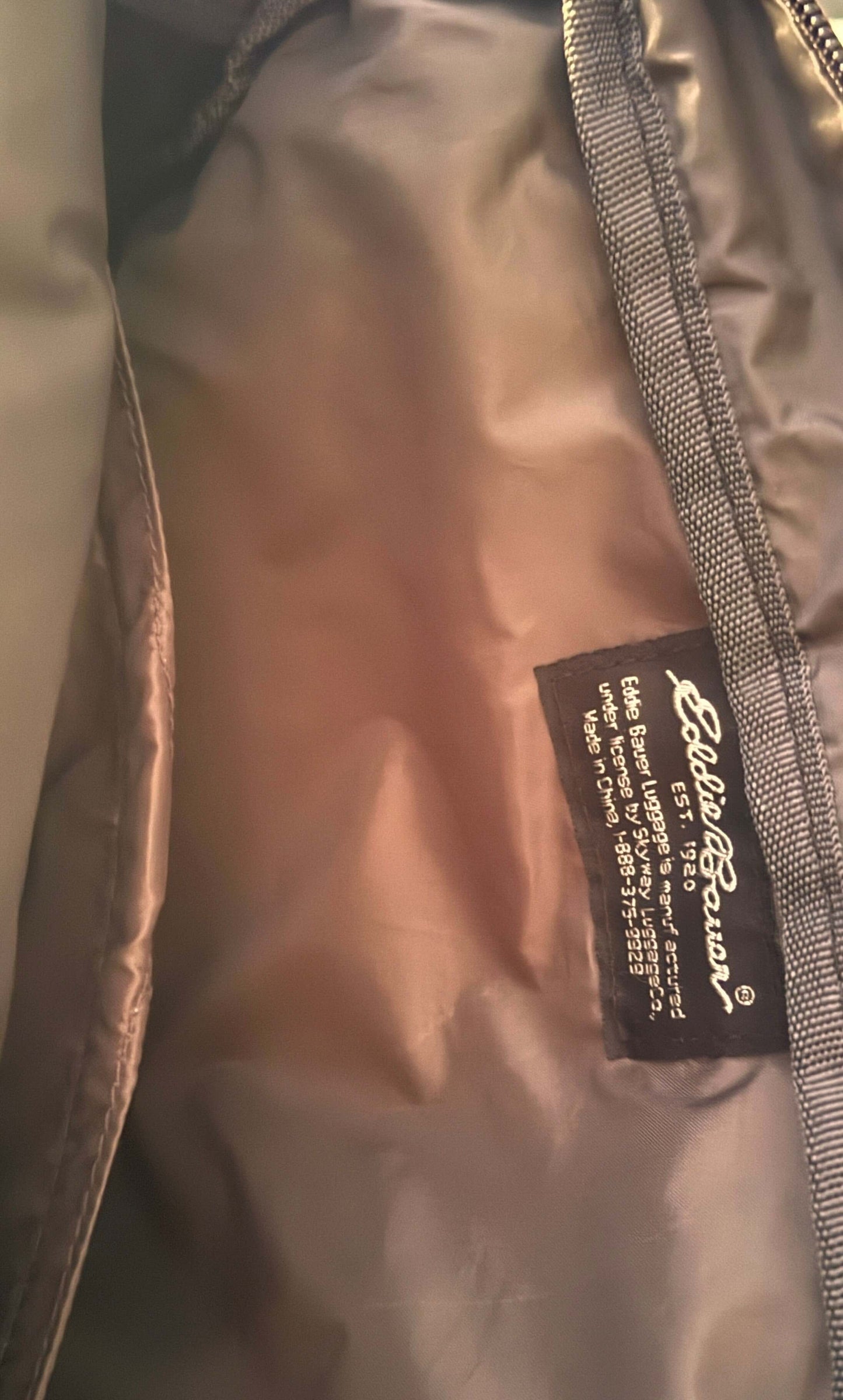 Interior view of Eddie Bauer vintage backpack featuring brand tag and durable lining, showcasing excellent condition.