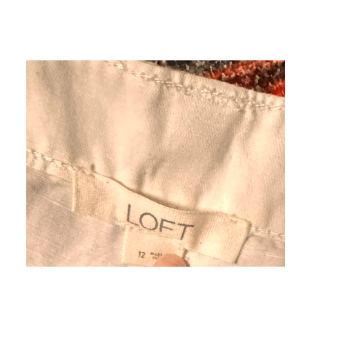 Label of size 12 white Loft shorts showcasing brand and care information.
