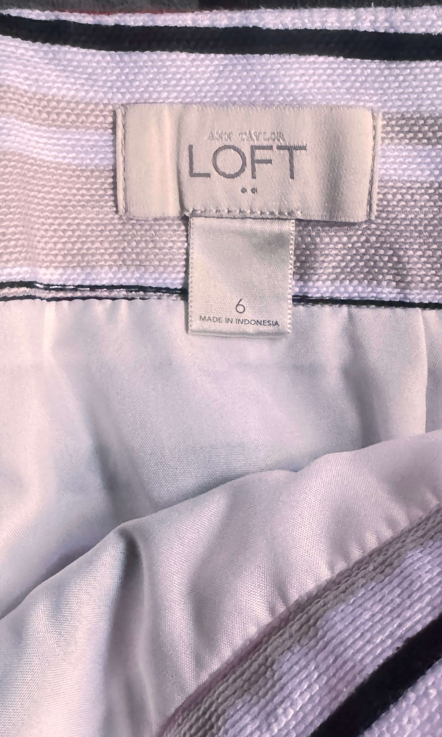 Close-up of a LOFT label on a garment with a white and black pattern.