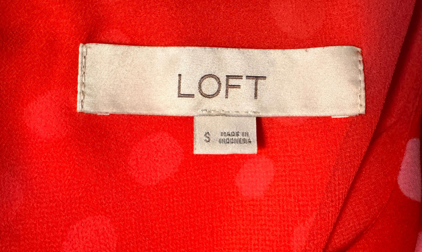 LOFT label on red sleeveless blouse with pink polka dots, size small, perfect for casual and office looks.