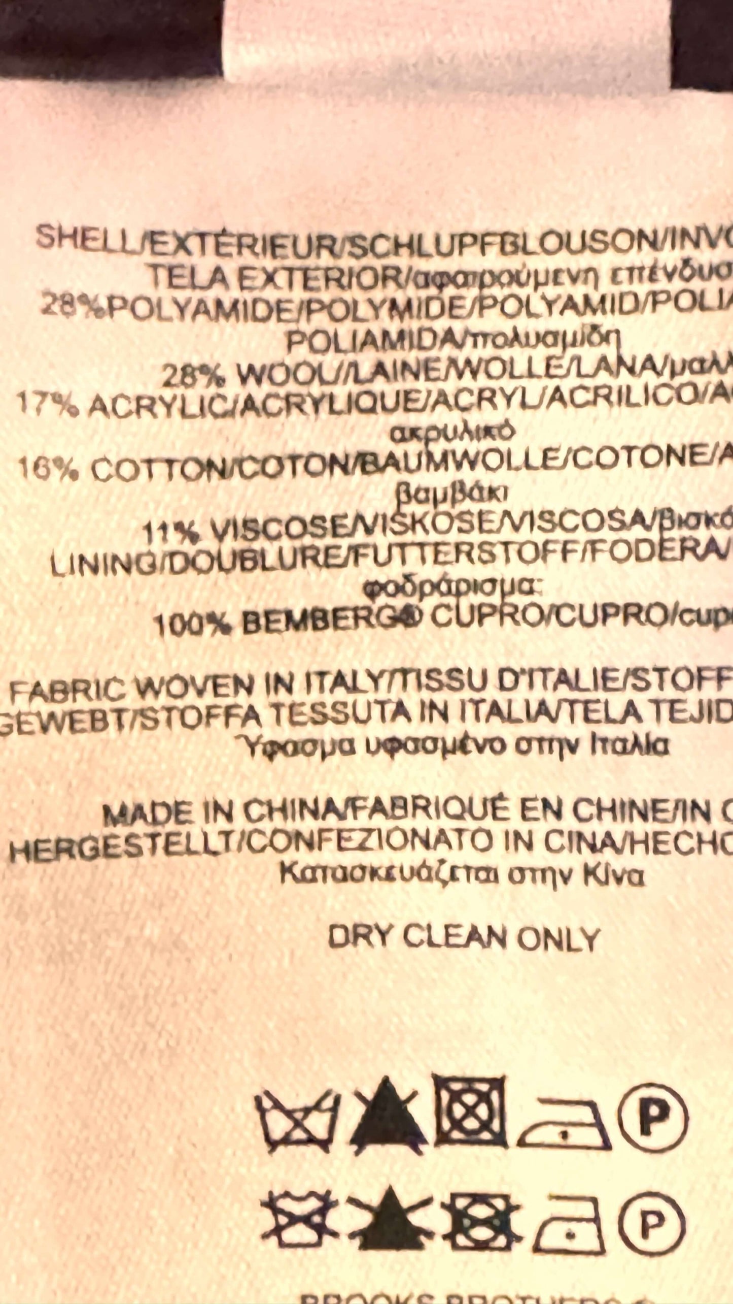 Fabric composition label with text and symbols on a beige background