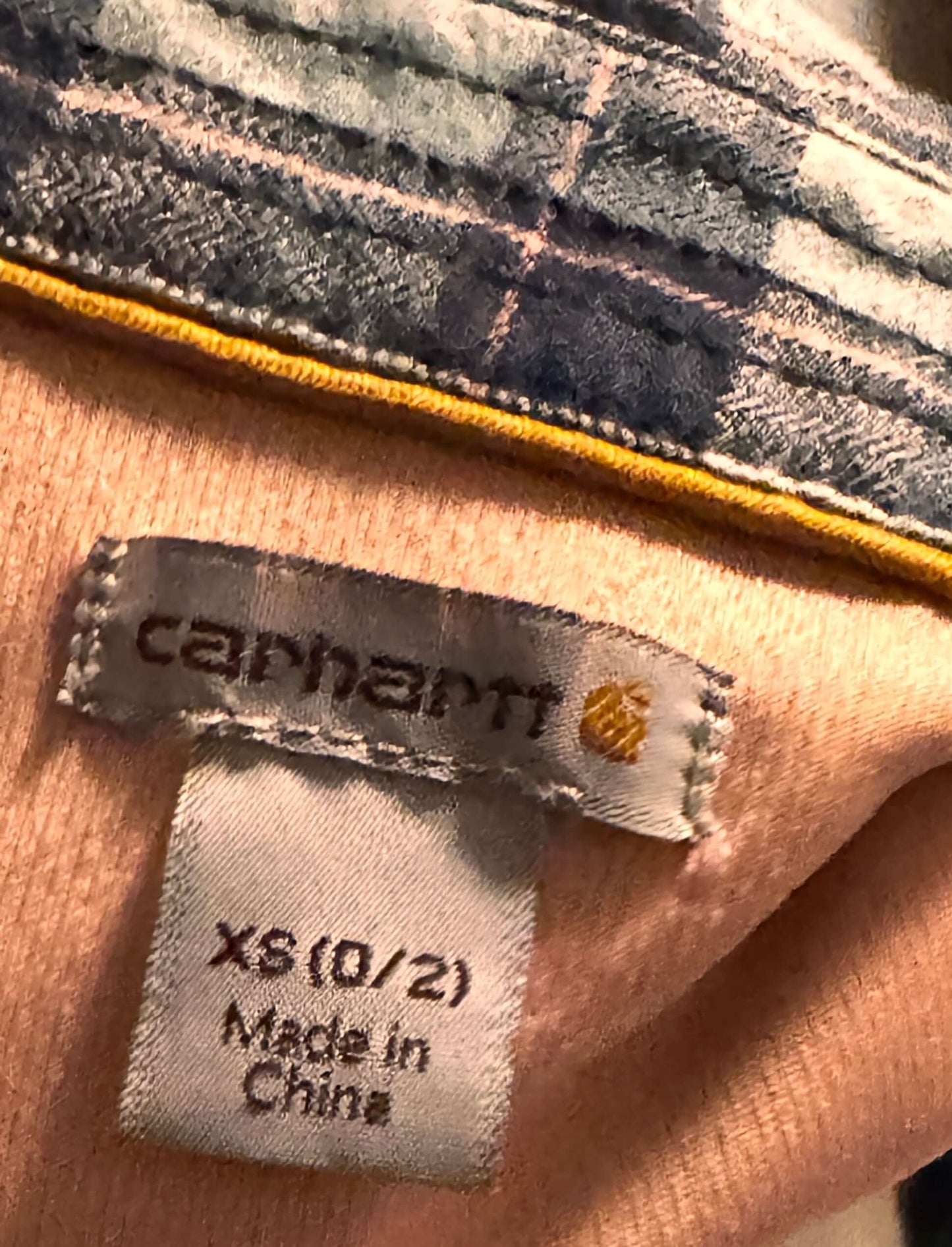 Close-up of a Carhartt label on a plaid fabric background
