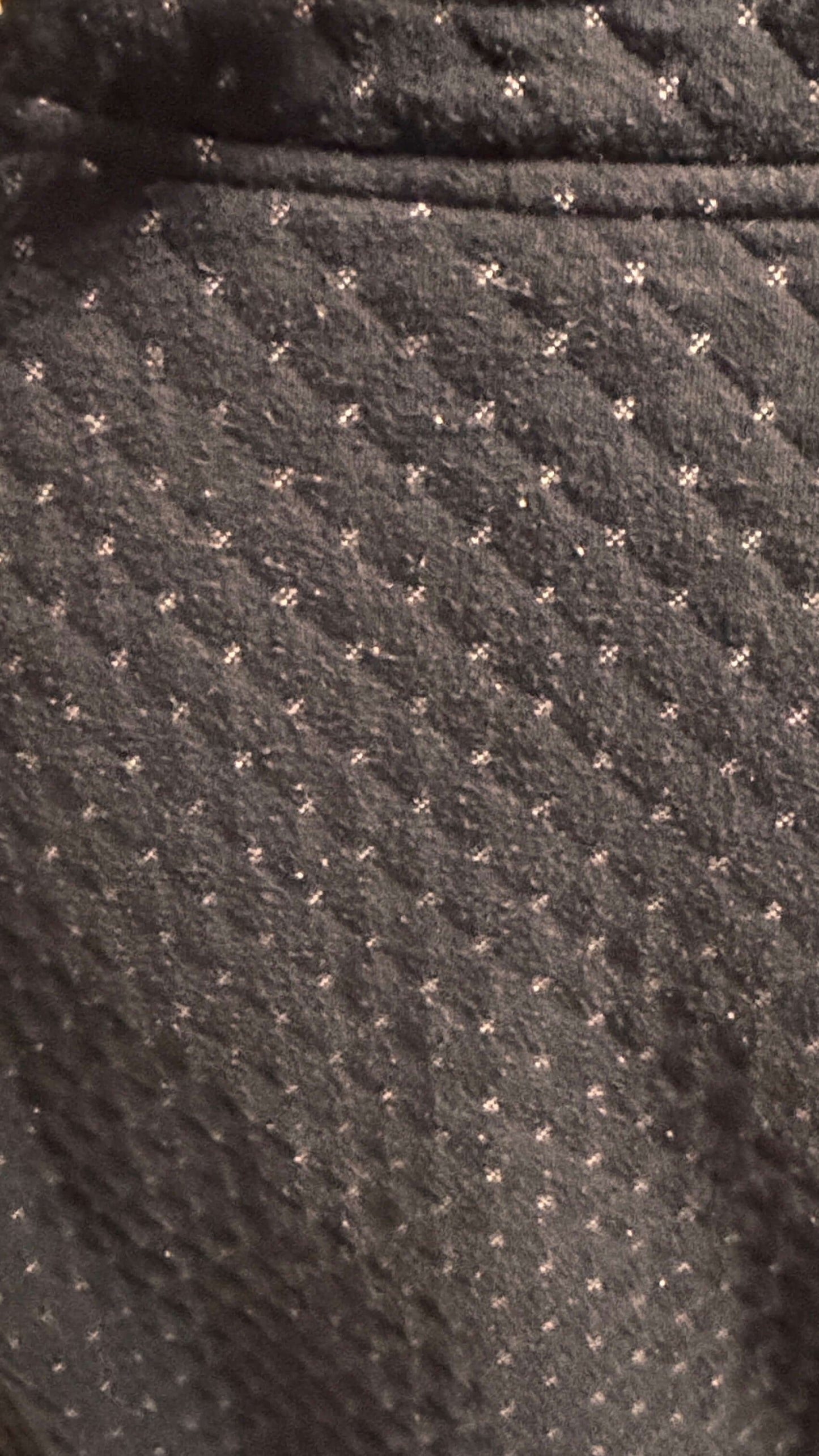 Close-up of a textured dark fabric with small white dots