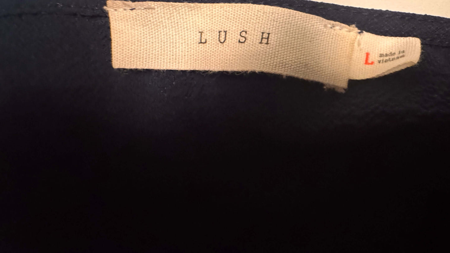 Lush brand label on a blue sleeveless blouse, size Large Petite, showcasing quality and style.