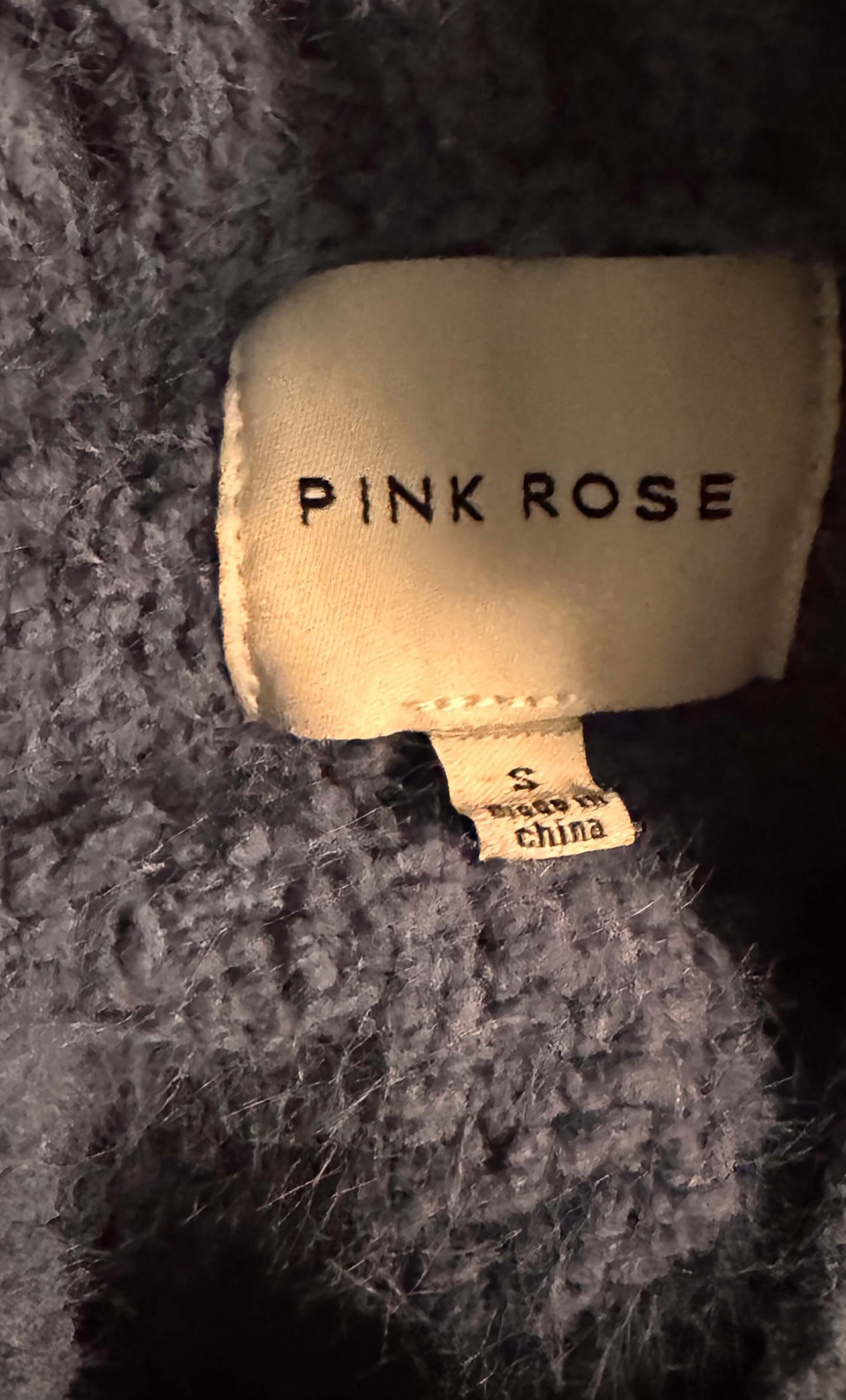 Pink Rose label on a textured fabric background