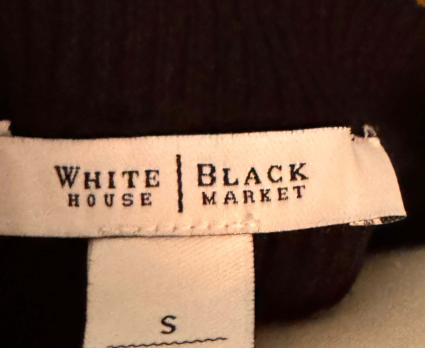 White House Black Market label on a garment with a dark background