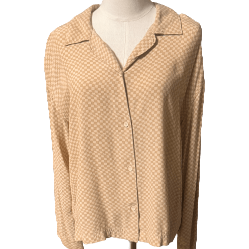 Beige patterned shirt on a mannequin against a white background