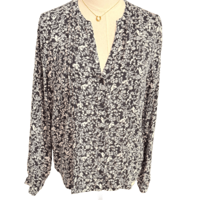 Floral patterned blouse on a mannequin against a white background