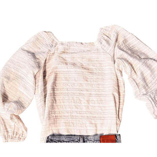 Light-colored blouse with long sleeves on a white background